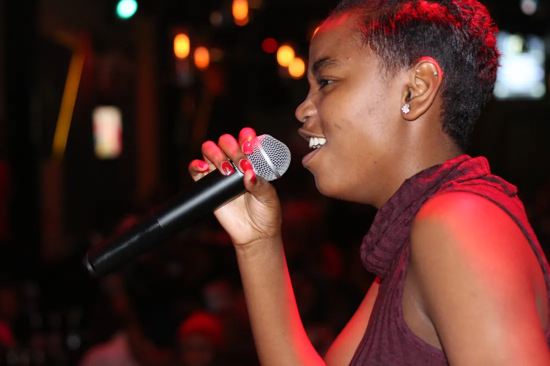 A singer enjoying her moment under red stage lighting