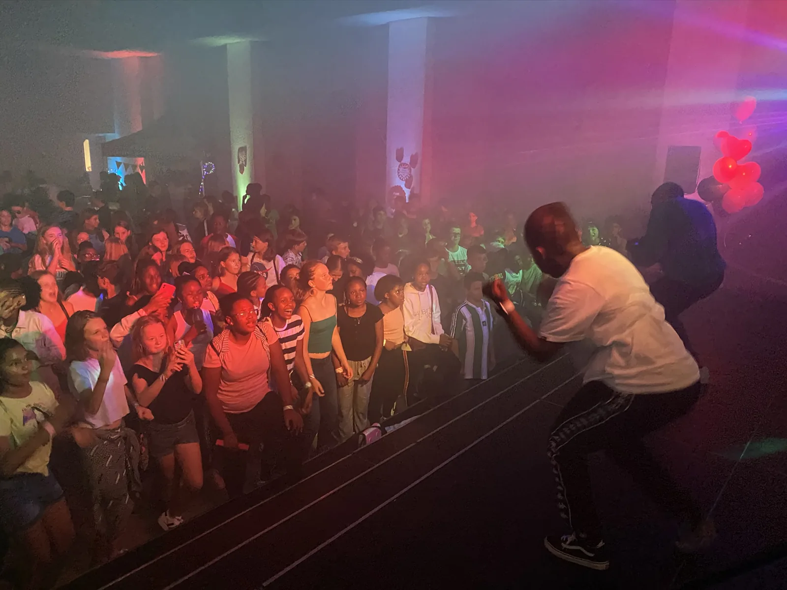 A performer engaging students at a school opening dance