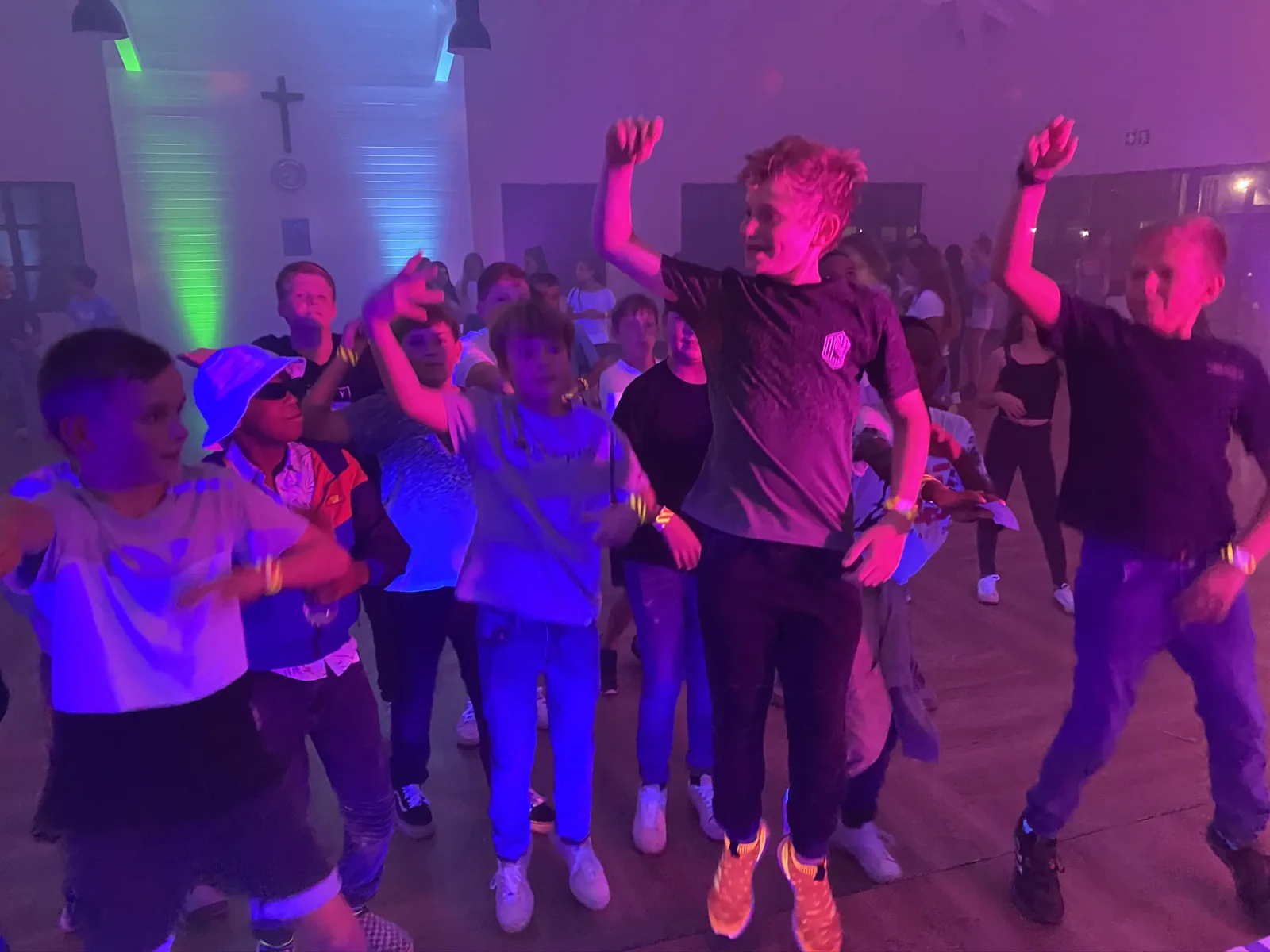 Students dancing under colourful lights at a school ball